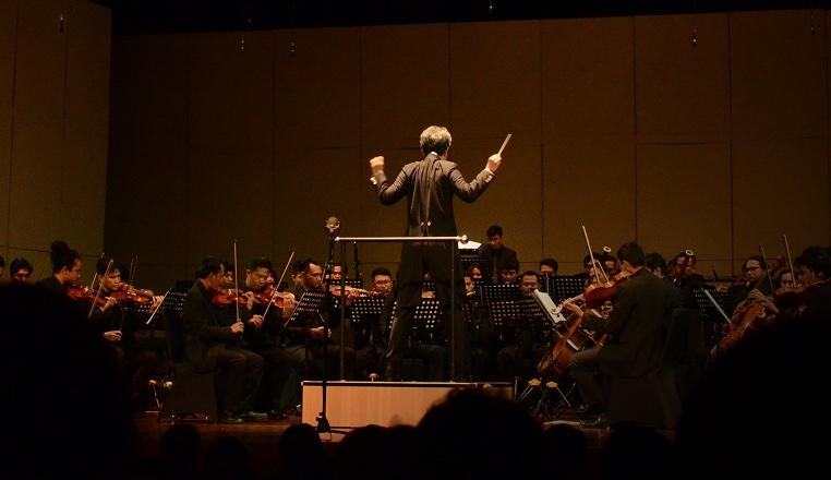 A conductor bringing separate sections in on cue